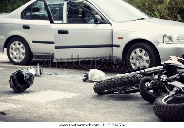 Car crash with a motorbike. Helmet and lights\
lying on the street