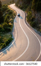 Car Crosses Country Road Winding In Twilight