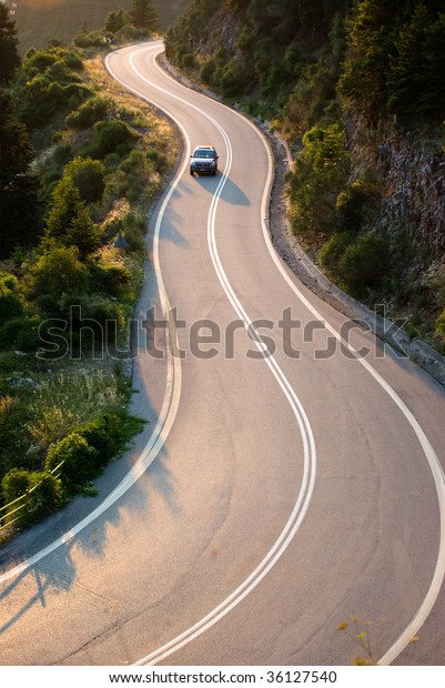 car crosses\
country road winding in\
twilight