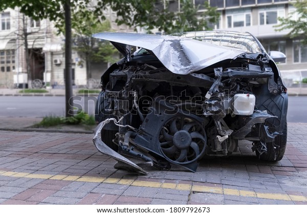 Car crush. Close-up\
front view of a wrecked car. Car after head-on collision. Bent hood\
and broken parts