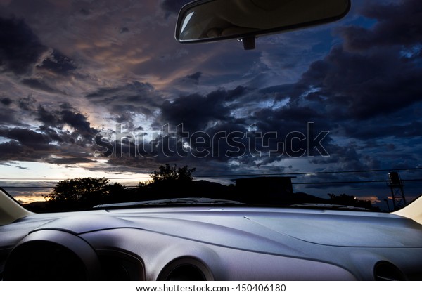 In the car,\
the dark rain clouds as\
background.