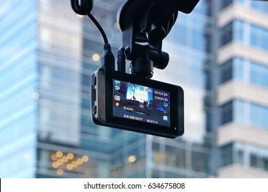 A car dash cam mounted on the front windshield recording the traffic ahead in case of an emergency situation or an accident