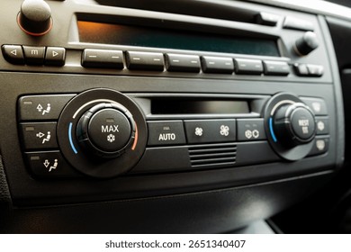 Car dashboard AC control panel with physical button and small LCD. Close up, detail show, snowflake pictogram to denote air conditioning, no people