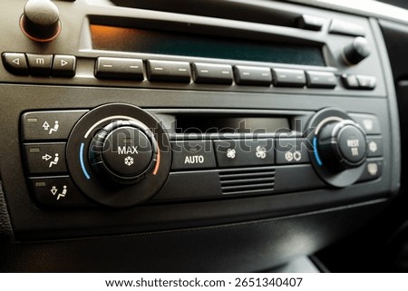 Car dashboard AC control panel with physical button and small LCD. Close up, detail show, snowflake pictogram to denote air conditioning, no people