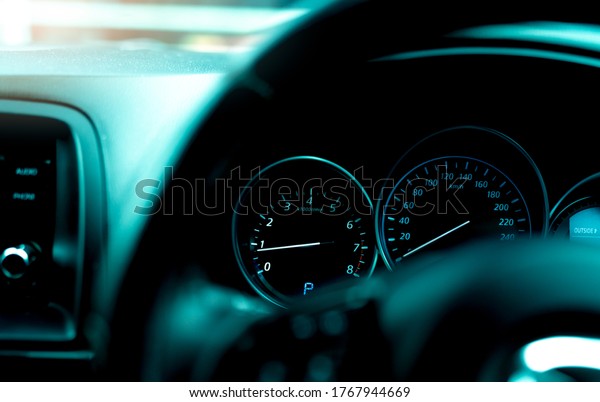 Car dashboard interior view. Car instrument panel\
with tachometer and speedometer. View from steering wheel to rpm\
gauge and speed meter. Car engine indicator. Closeup dashboard with\
auto light.