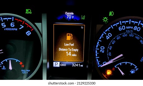 Car Dashboard With Low Fuel Warning Displayed On The Monitor. High Fuel Prices Concept With A Modern Car Dash, Vibrant Colors.