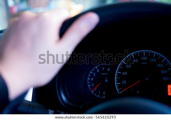 Car\
dashboard modern automobile control illuminated panel speed\
display. human hand on hand beside car\
dashboard.