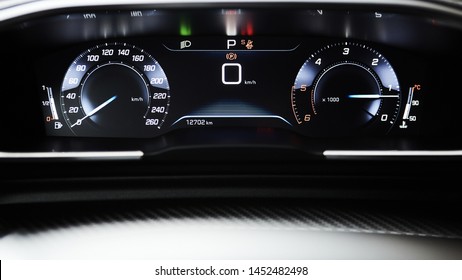 Car dashboard panel with speedometer, tachometer, odometer, fuel gauge and gear position indicator.