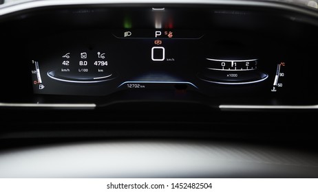 Car dashboard panel with speedometer, tachometer, odometer, fuel gauge and gear position indicator.