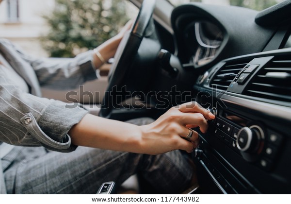Car
dashboard. Radio closeup. Woman sets up
radio