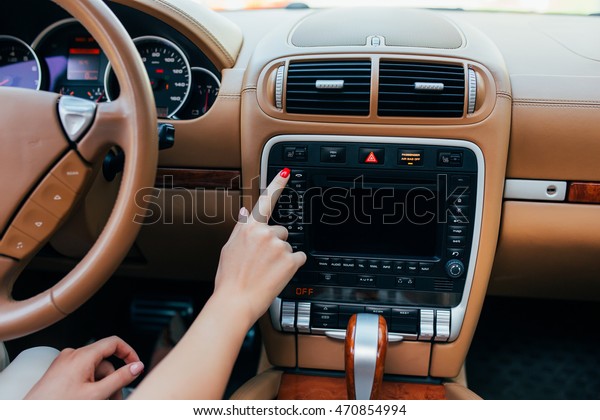 Car\
dashboard. Radio closeup. Woman sets up\
radio