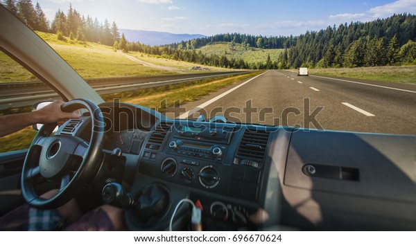 Car dashboard and steering wheel inside of car.\
Travel in the mountains