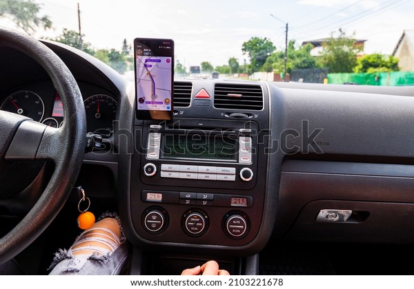 In car dashboard view\
with smartphone on Waze maps. Driver using Waze maps in Bucharest,\
Romania, 2022