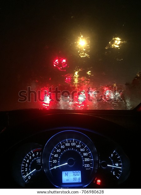 Car dashboard\
and wet windshield from a heavy rain in a heavy traffic in Chiang\
Mai, Thailand. selective\
focus.