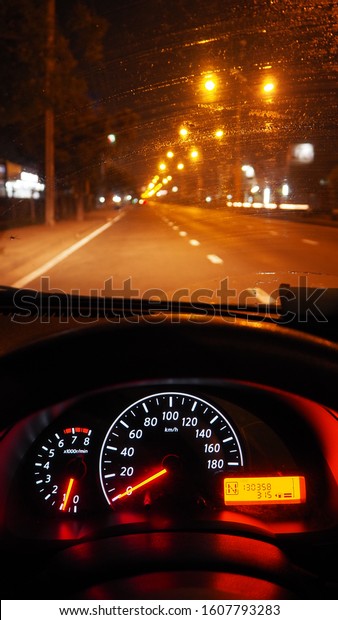 Car dashboard and\
window, take a break and park the car on the side of the road at\
night. Driving at night.