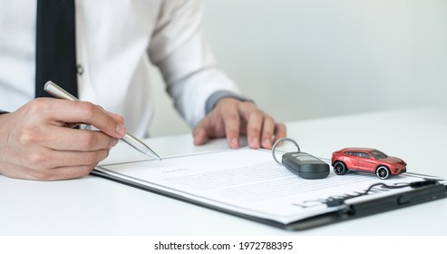 Car Dealer Businessman Signing Car Insurance Document Or Lease Paper. Car Loan And Insurance Concept.