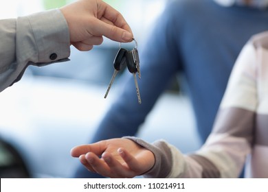 Car Dealer Giving Keys To A Customer In A Car Shop