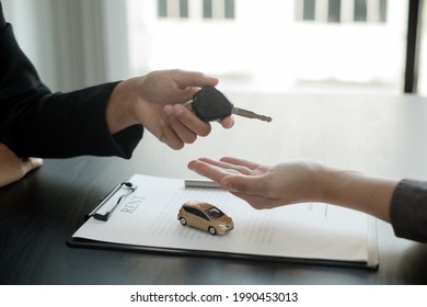 The car dealer provides advice on loans, insurance details, and car rental information, and delivers the car with the keys after the rental contract is signed. - Shutterstock ID 1990453013