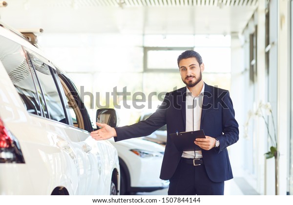 A\
car dealer shows a auto in a showroom. Auto\
business.