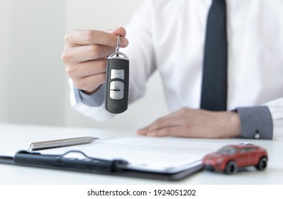 Car dealers or insurance managers cover and protect against damage and the risk of driving, Hold the car keys, Protecting and after-sales care concept. - Shutterstock ID 1924051202