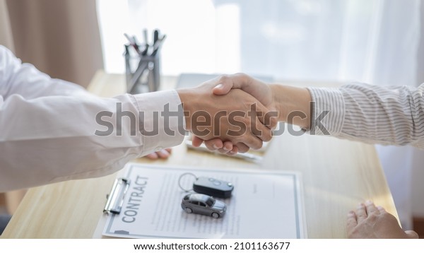 Car\
dealers or insurance dealers shake hands to congratulate the\
customers who have signed the car purchase contract and insurance,\
Buy a new car, Shaking hands with success\
concept.