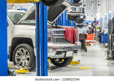 Car Dealership Auto Service Area. Clients Vehicles On Automotive Lifts Under Maintenance. From Oil Change To Complicated Timing Chain Replacement.