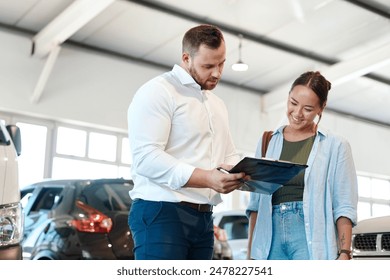 Car, dealership or documents with salesman and customer in showroom for conversation, deal or offer. Contract, finance or insurance with agent and asian woman in discussion for vehicle purchase - Powered by Shutterstock