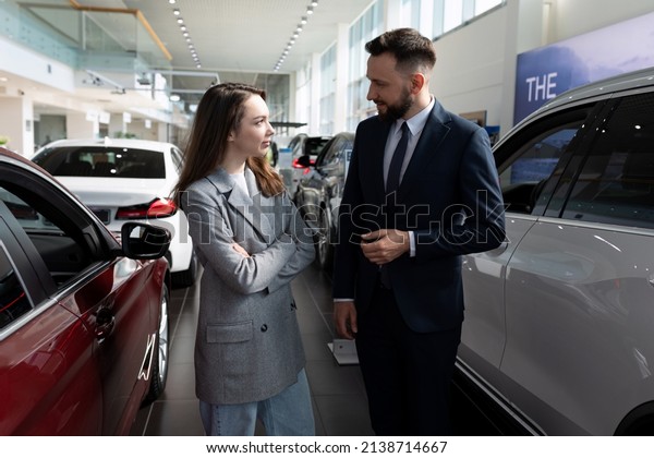 car\
dealership employees communicate among new\
cars
