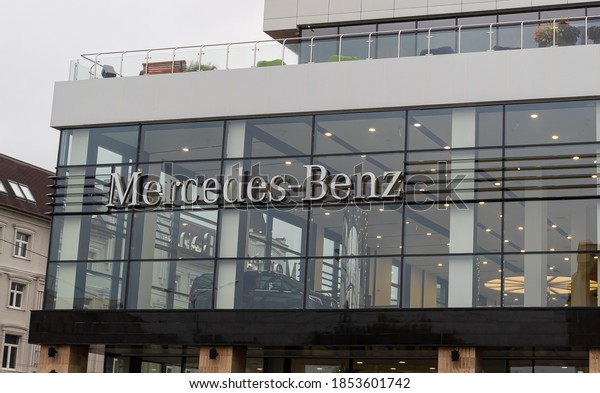 car dealership selling luxury and\
budget Mercedes-Benz cars in the city in cloudy\
weather.