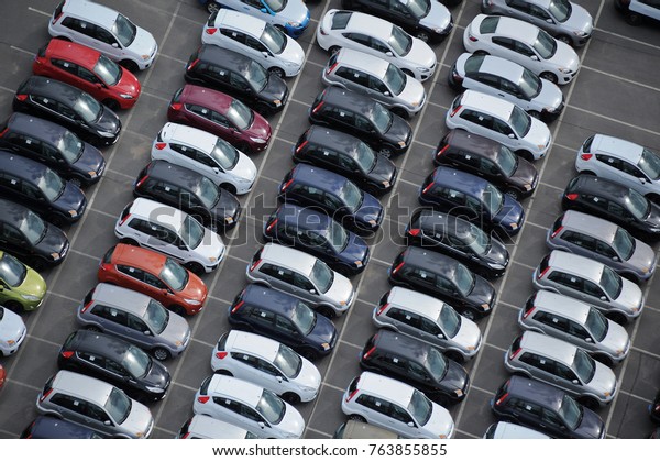 car dealership yard at a port, cars waiting to\
get through customs