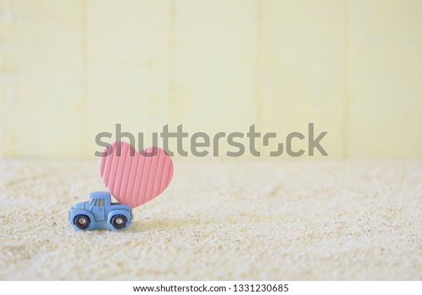 Car delivering heart\
on the white sand.