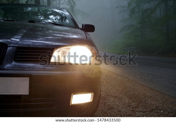 Car in Dense Fog.\
Dangerous Road Conditions. Morning Time Driving in Fog. Headlight\
and fog light on the car