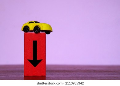 Car Depreciation Value, Price Drop Concept. Toy Car And Red Wooden Cubes With Downward Arrow.