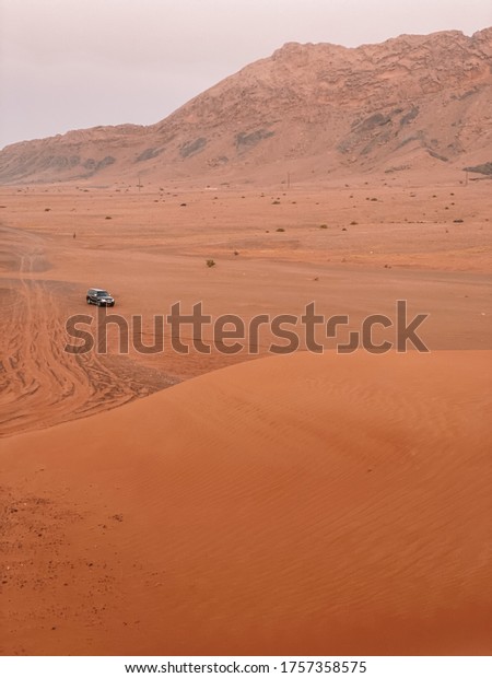 Car in the desert dune with red sand in Dubai, UAE\
in June 2020
