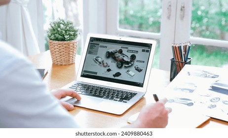 Car design engineer analyze car prototype for automobile business at home office. Automotive engineering designer carefully analyze, finding flaws and improvement for car design with laptop Synchronos