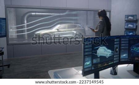 Car design engineers in a lab testing the aerodynamics and body of a new development modern, cutting edge eco-friendly electric car using a wind tunnel with steam.