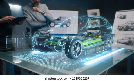 Car design engineers using holographic app in digital tablet. Develop modern innovative high-tech cutting edge eco-friendly electric car with sustainable standards. They test the aerodynamic qualities - Shutterstock ID 2219825287
