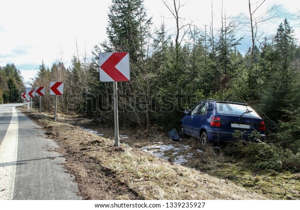 A car destroyed during\
the traffic accident. The car is abandoned and stands by the road\
in the trees. 