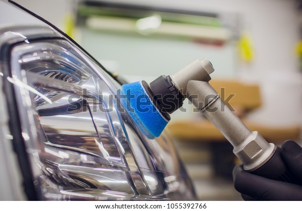 Car detailing auto mechanic buffing and\
polishing car headlight