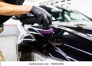 Car detailing - Hand with orbital polisher in auto repair shop. 