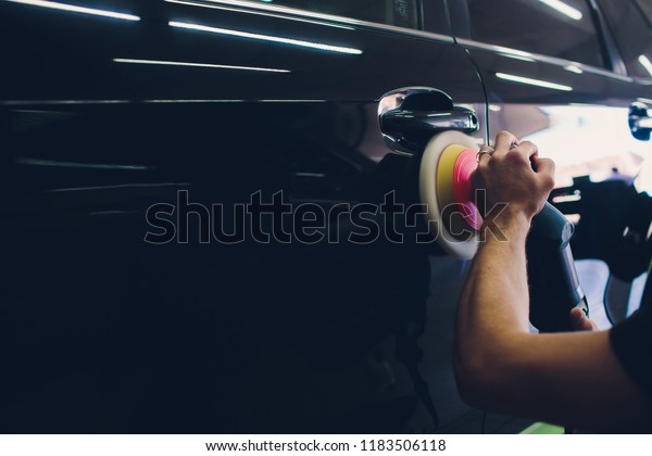 Car detailing - Hands with orbital polisher in auto\
repair shop