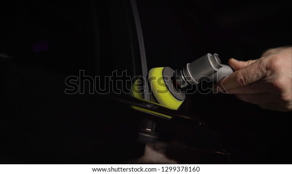 Car\
detailing - Hands with orbital polisher in auto repair shop.\
Selective focus. Car polishing and LCP\
correction