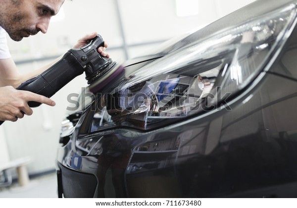 Car detailing - Hands with orbital\
polisher in auto repair shop. Selective\
focus.