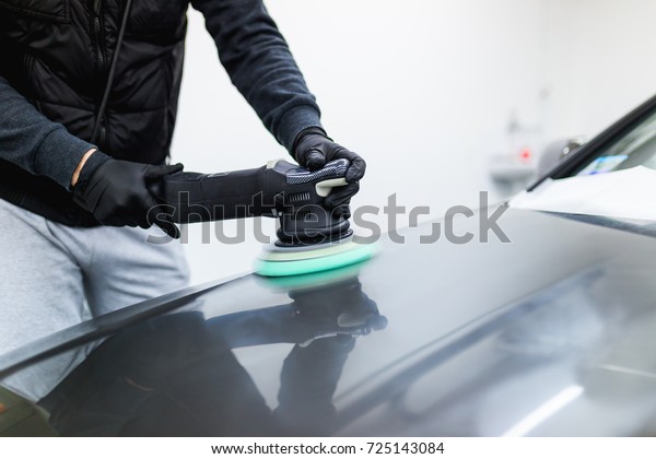 Car detailing - Hands with orbital\
polisher in auto repair shop. Selective focus.\
