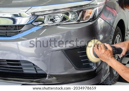 Car detailing - Male mechanic holding car polishing machine. Auto industry, car polishing and painting and repair shop.