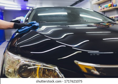 Car detailing - Man applies nano protective coating to the car. Selective focus.