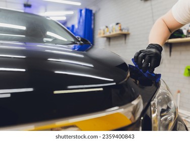 Car detailing - Man applies nano protective coating to the car. Selective focus