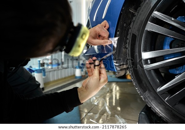 Car detailing. Man applies nano\
protective coating to the car in car detailing\
service