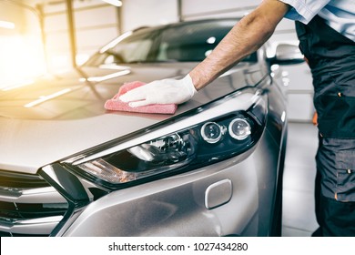 Car detailing - the man holds the microfiber in hand and polishes the car. Selective focus.