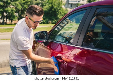 Car detailing - the man holds the microfiber in hand and polishes the car. Selective focus. Car detailing series : Worker cleaning red car.  - Shutterstock ID 1464311951